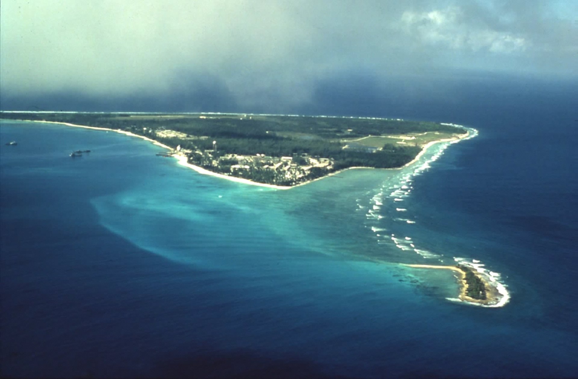 Aerial view of an island, reef and surrounding ocean — land brought under territorial jurisdiction.